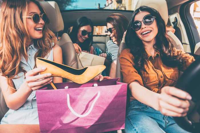 Девушки в машине рассматривают покупки