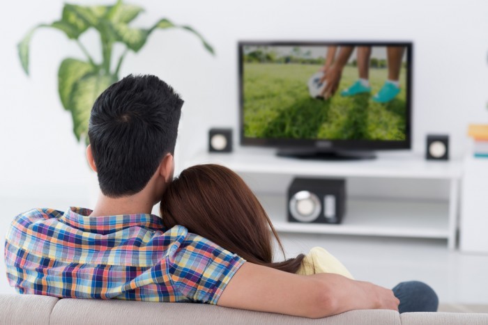 Парень и девушка смотрят телевизор