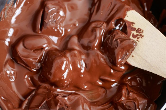 Шоколадная глазурь в кастрюльке с деревянной лопаткой