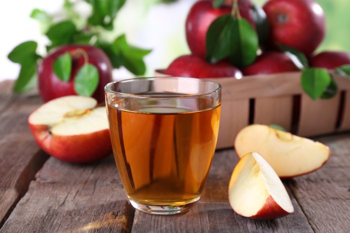 Стакан яблочного сока возле яблок