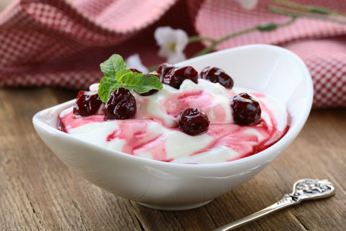Йогурт с вишнями с белой тарелке