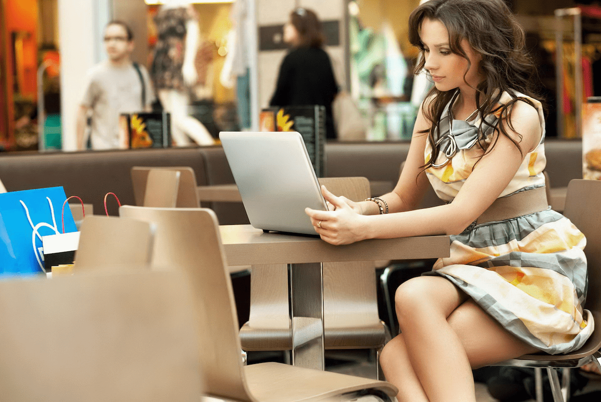 Успешная девушка в кафе с ноутбуком