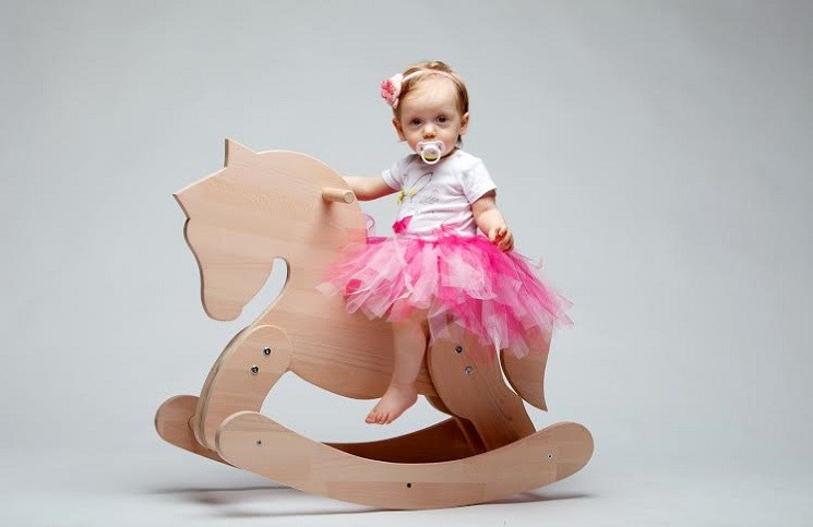 Маленькая девочка на деревянном коне