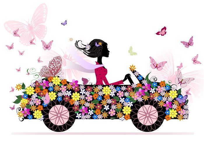 Девушка за рулем машины в цветках и бабочках