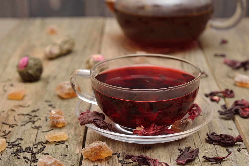 Прозрачная чашка с красным чаем,красными листьями и сухофпуктами