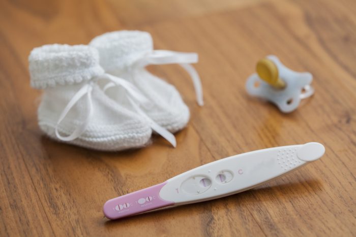 Тест на беременность,соска и детские вязаные тапочки