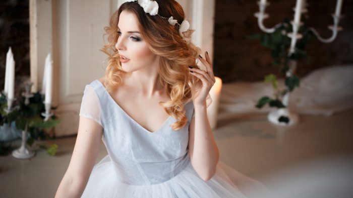 Девушка в серо-голубом платье и с венком из белых цветов на голове