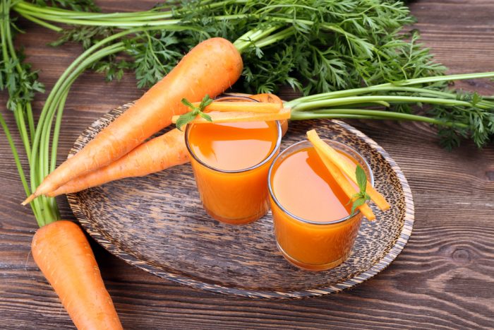 Морковный сок на подносе с морковкой